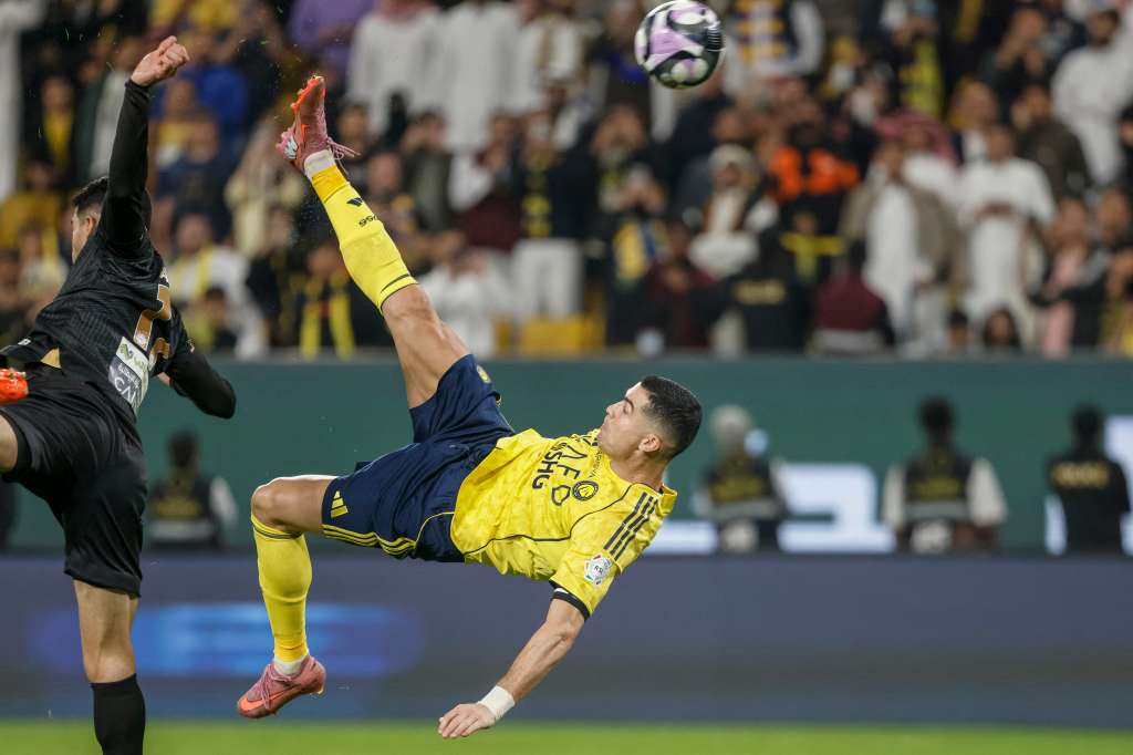 El delantero portugués #07 de Nassr, Cristiano Ronaldo (D), patea el balón para marcar el cuarto gol de su equipo durante el partido de fútbol de la Liga Profesional Saudí entre Al-Nassr y Al-Khaleej en el Parque Al-Awwal en Riad el 23 de noviembre de 2025.