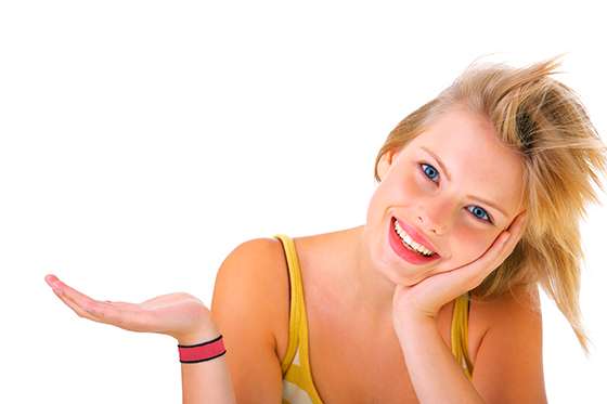 Showing, giving or presenting. Portrait of a beautiful young woman, holding out her hand as displaying something. Ready for you to add text.