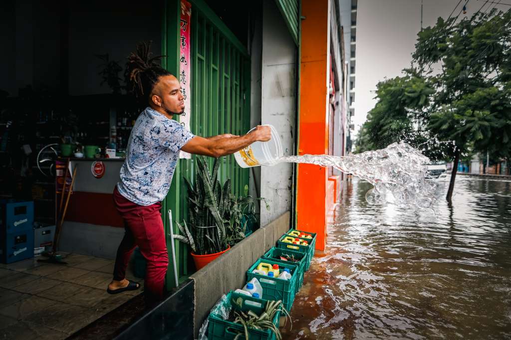 AME362. BUENOS AIRES (ARGENTINA), 20/03/2024.- Un hombre evacua el agua de su negocio frente a una calle inundada por la lluvia este miércoles, en Buenos Aires (Argentina). La capital argentina, Buenos Aires, y la provincia homónima amanecieron este miércoles con alerta por fuertes tormentas y vientos, que han causado daños materiales y la cancelación de vuelos en los principales aeropuertos. El Servicio Meteorológico Nacional (SMN) elevó a naranja la alerta por tormenta, que implica lluvias intensas con caída de 50 a 90 milímetros de agua con ráfagas de más de 90 kilómetros por hora y caída de granizo y alerta amarilla por vientos de 30 a 70 kilómetros por hora con ráfagas de más de 100 kilómetros por hora. EFE/ Juan Ignacio Roncoroni