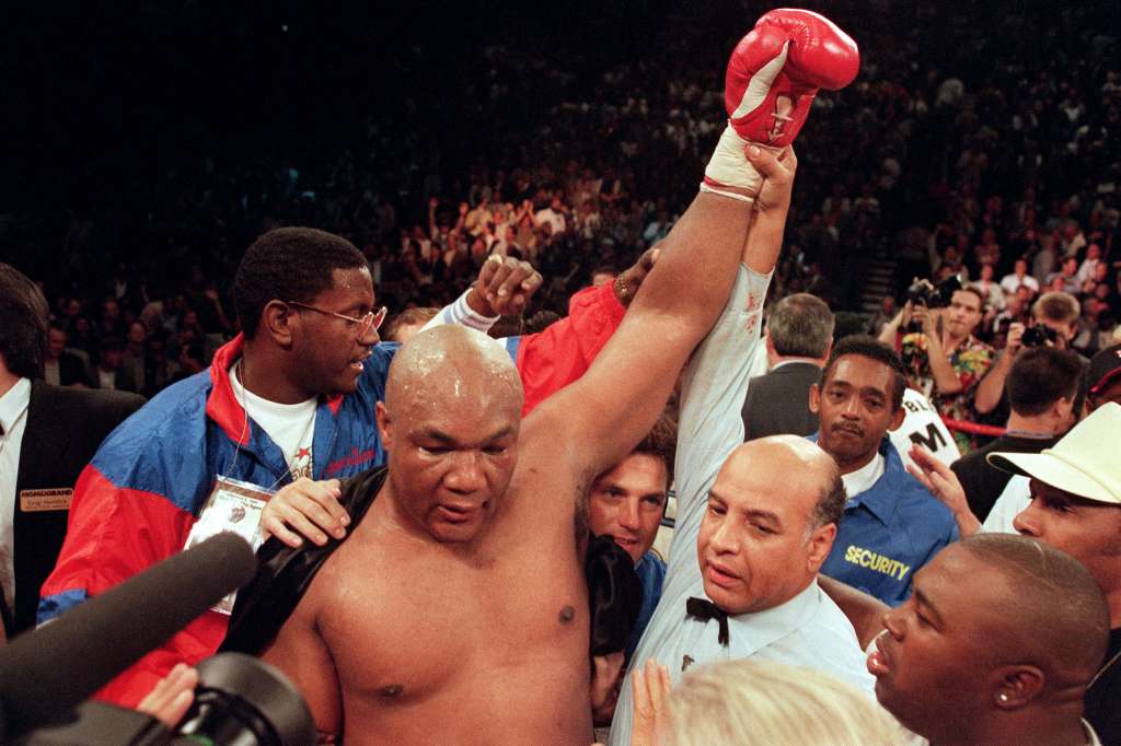 (FILES) Referee Joe Cortez (R) holds George Foreman's arm up in victory after Foreman knocked Michael Moorer out in the tenth round of their scheduled 12 round IBF/WBA heavyweight title fight, on November 5, 1994 in Las Vegas, Nevada.