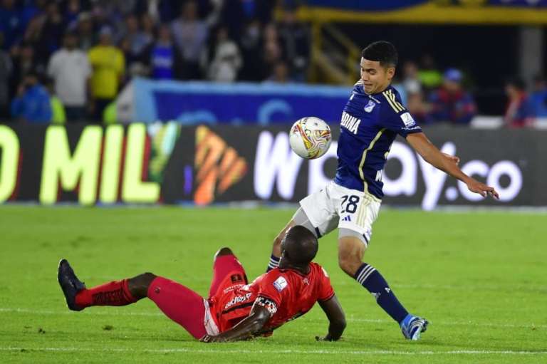 Stiven Vega, de Millonarios, disputa un balón con Luis Paz, de América.