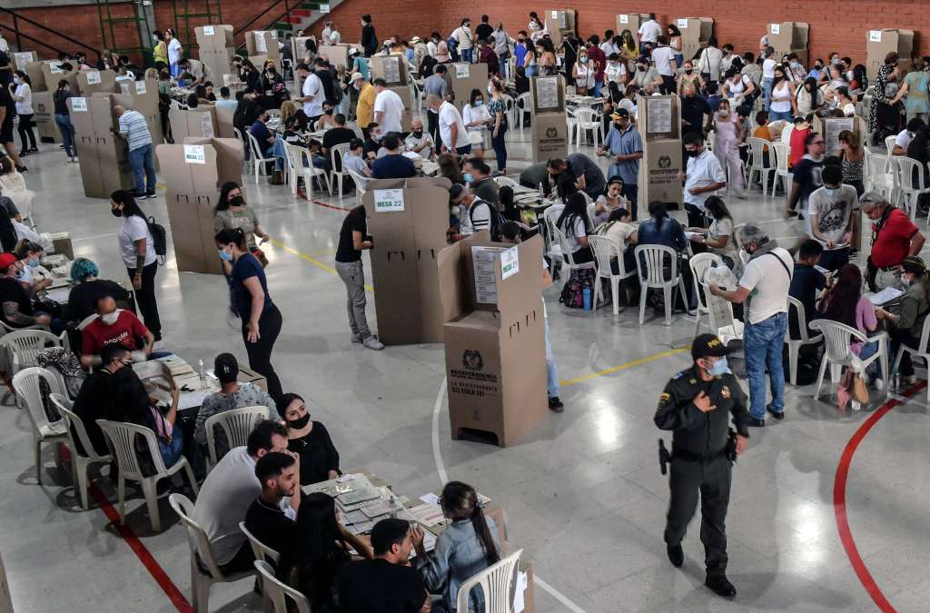 Las personas se acercan a último minuto a los puestos de votación.