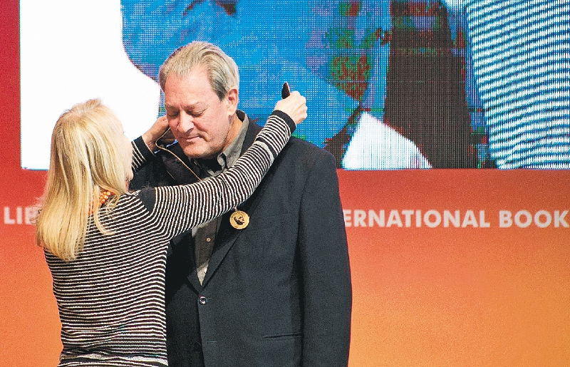 Paul Auster recibe de Silvia Fuentes la medalla en honor a Carlos Fuentes. / AFP