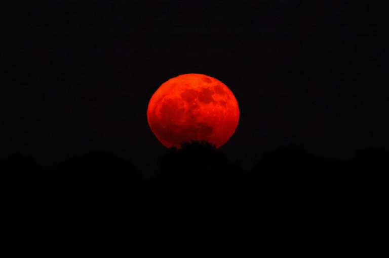 Esta imagen tomada desde una posición en el lado israelí de la frontera con la Franja de Gaza muestra la luna llena, conocida como la «Luna de fresa» que sale el 11 de junio de 2025.