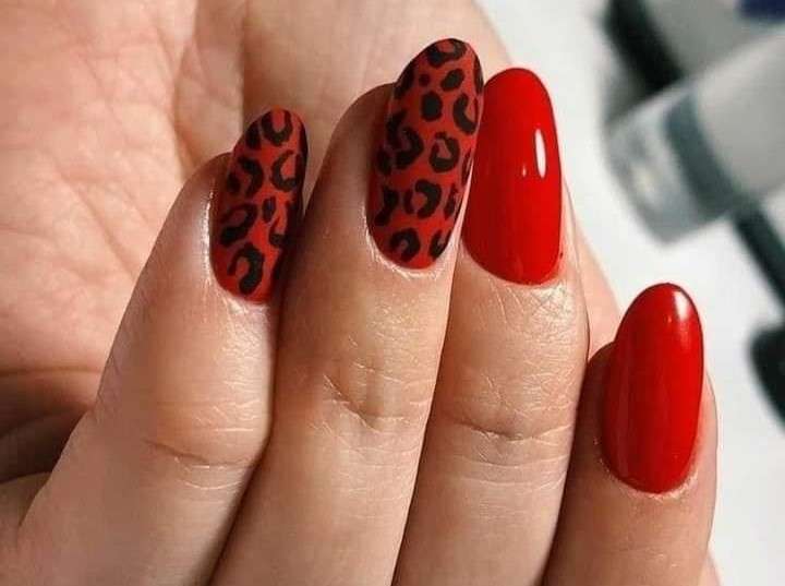 Este diseño es audaz y moderno. Necesitarás esmalte de uñas rojo, esmalte de uñas negro y un pincel delgado. Pinta tus uñas de rojo y deja que se sequen. Luego, con el pincel delgado y el esmalte negro, dibuja pequeñas manchas de leopardo en tus uñas. No te preocupes si no son perfectas, el estampado de leopardo se ve mejor cuando es un poco irregular.
