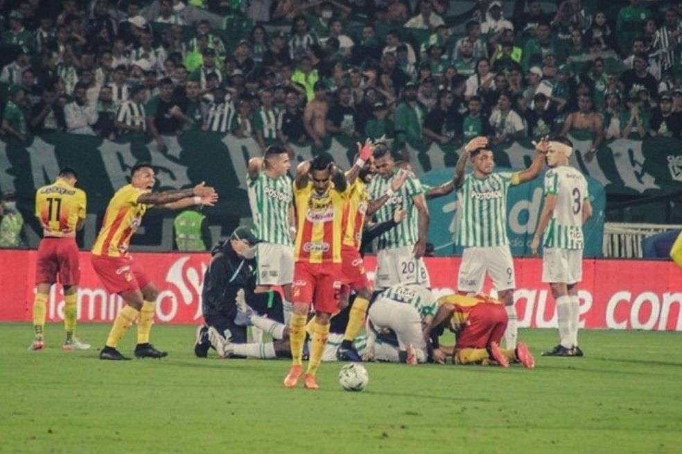 Los jugadores y el árbitro piden asistencia para el futbolista en medio del partido.