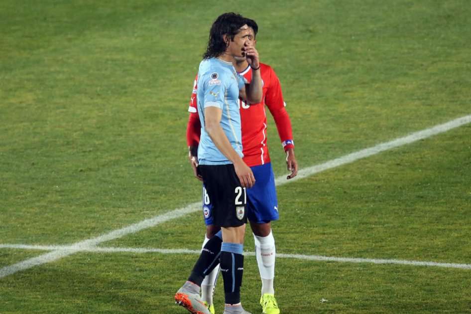 El defensor chileno Gonzálo Jara provoca a Edinson Cavani. Foto: AFP