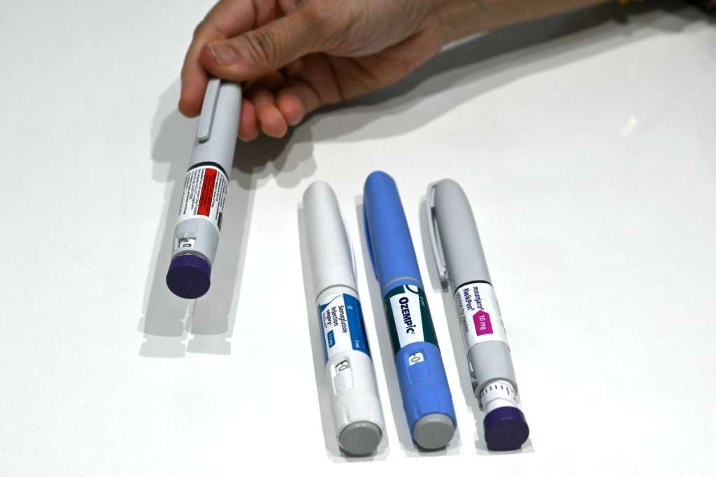 This photograph taken on March 17, 2026 shows obesity doctor and consultant Swati Pradhan showing various GLP-1 self-injectable devices at her clinic in Mumbai.