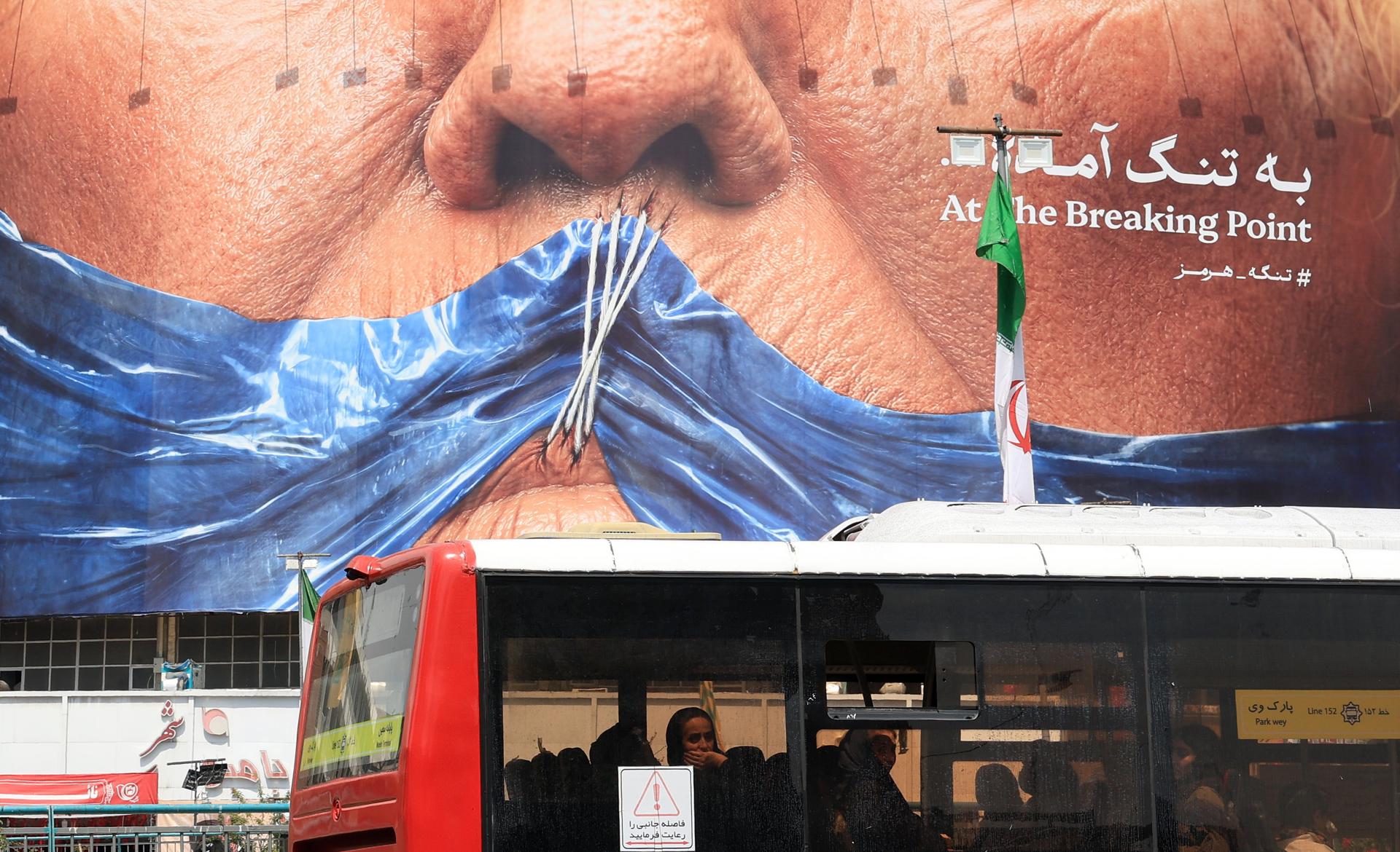 TEHRAN (IRAN(Islamic Republic Of)), 02/05/2026.- Iranians in a public bus drive past a huge anti-US billboard referring to US president Donald Trump and Strait of Hormuz at Valiasr square in Tehran , Iran, 02 May 2026. The conflict between Iran and the United States over the Strait of Hormuz continues, as the ceasefire between the two countries has been extended indefinitely and diplomatic negotiations are ongoing. (Estados Unidos, Teherán) EFE/EPA/ABEDIN TAHERKENAREH