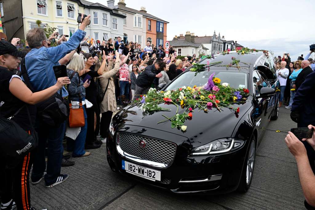Bray (Ireland), 08/08/2023.- Fans gather for a 'last goodbye' to the Irish singer Sinead O'Connor as her hearse passes by her former home in Bray, Co Wicklow, Ireland, 08 August 2023. The funeral cortege passed by her old home on the way to the private burial service for the 56-years old singer, who was found dead at her home in London on 26 July 2023. (Irlanda, Londres) EFE/EPA/Bryan Meade
