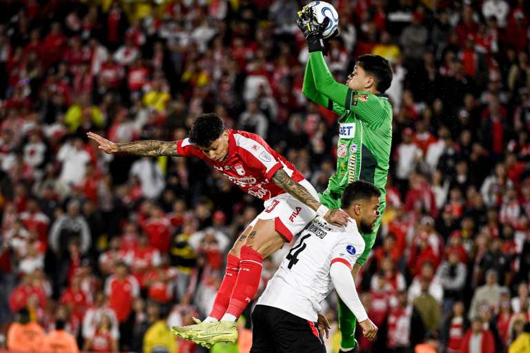 Alexis Zapata, quien entró en el segundo tiempo, disputando un balón con el arquero rival en el partido entre Santa y Caracas por la Copa Sudamericana en el estadio El Campín de Bogotá.