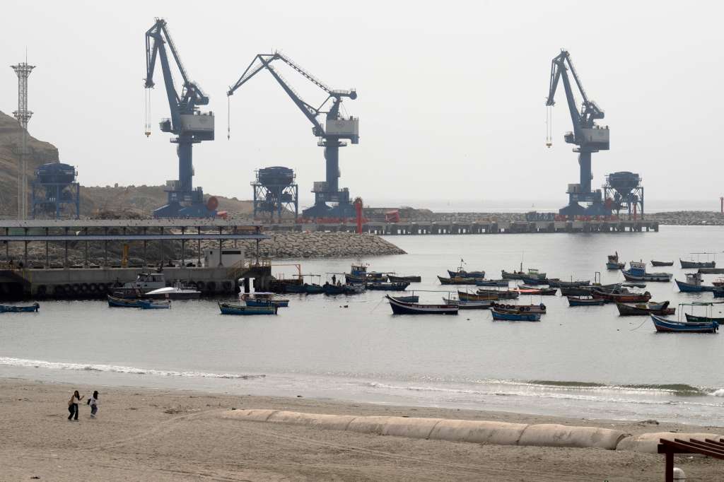 The Chancay "megaport" cranes are seen from the town's harbor, where traditional fishing boats rest, 78 kilometers north of the Peruvian capital Lima, on October 29, 2024.