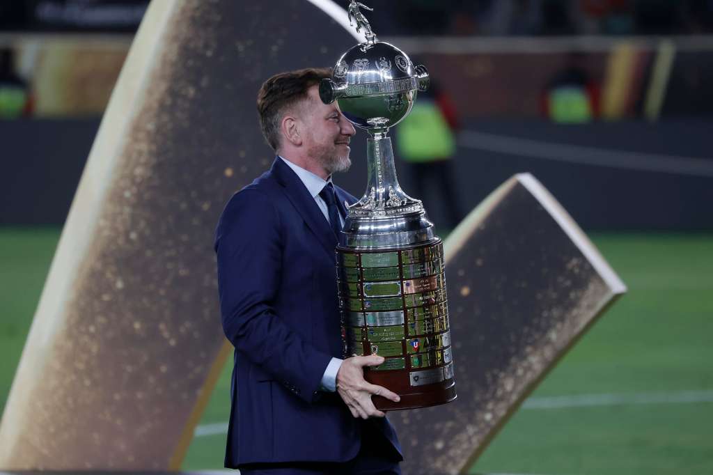 AMDEP9833. LIMA (PERÚ), 29/11/2025.- El presidente de la Conmebol Alejandro Domínguez lleva al trofeo de la Copa Libertadores para jugadores de Flamengo este sábado, en el estadio Monumental U, en Lima (Perú). EFE/ José Jácome