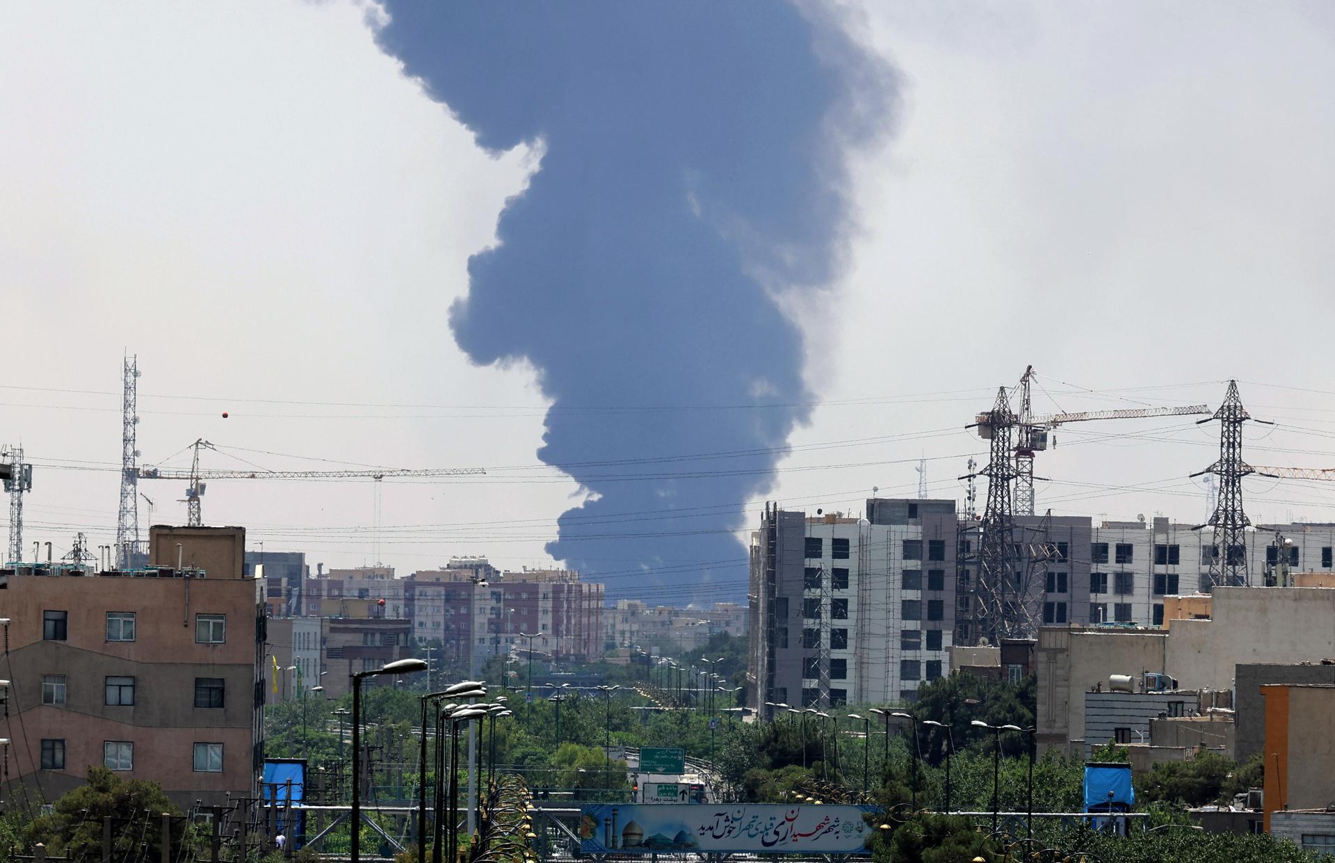 TEHRAN (Iran (Islamic Republic Of)), 15/06/2025.- Smoke from an oil refinery rises over residential buildings in southern Tehran, Iran, 15 June 2025. Israel continued to target sites related to Iran's nuclear program and energy facilities, after launching strikes across Iran since 13 June. In retaliation, Iran launched waves of missiles and drones toward Israel. (Teherán) EFE/EPA/ABEDIN TAHERKENAREH