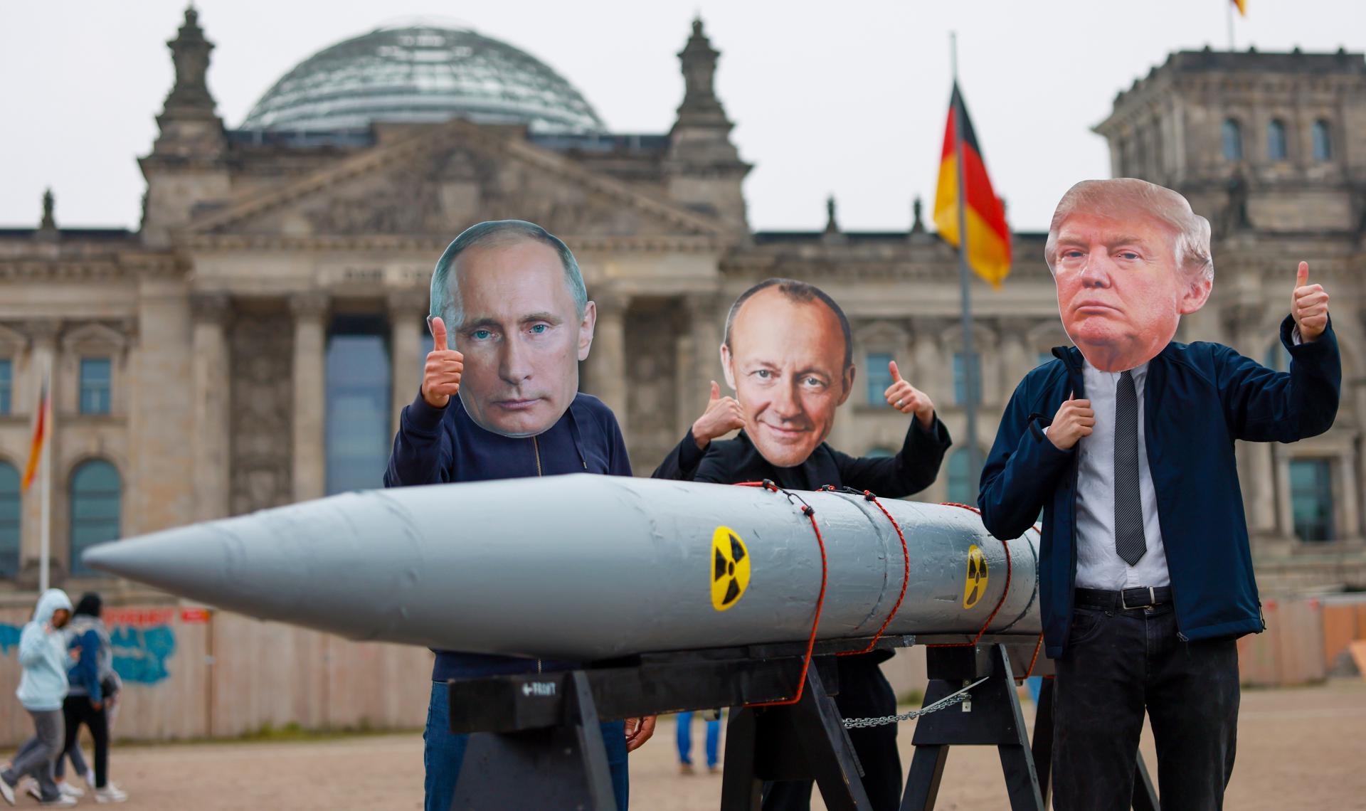 Berlin (Germany), 18/04/2025.- Peace activists dressed as US President Donald Trump (R), designated German Chancellor Friedrich Merz (C), and Russian President Vladimir Putin (L) pose with a three-meter-long nuclear bomb, made of polystyrene, during a protest in front of the Reichstag building in Berlin, Germany, 18 April 2025. (Protestas, Alemania) EFE/EPA/HANNIBAL HANSCHKE