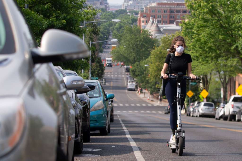 -FOTODELDÍA- WASHINGTON, 09/06/2023.- Una chica con mascarilla monta en un patinete eléctrico este viernes en Washington. Las autoridades han decretado una alerta naranja por la calidad del aire en la capital estadounidense tras dos días de contaminación como consecuencia del humo proveniente de los incendios canadienses. EFE/MICHAEL REYNOLDS