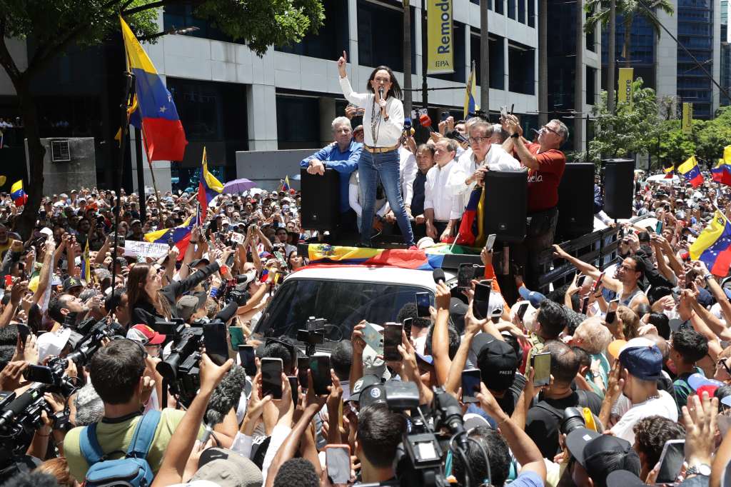 AME3983. CARACAS (VENEZUELA), 28/08/2024.- La líder opositora venezolana, María Corina Machado (c), pronuncia un discurso ante seguidores este miércoles, en una manifestación en Caracas (Venezuela). Machado aseguró que los militares del país "saben lo que tienen que hacer en esta hora", cuando se cumple un mes de las elecciones presidenciales, cuyo resultado oficial -que favoreció a Nicolás Maduro- la exdiputada señala de fraudulento, igual que buena parte de la comunidad internacional. EFE/ Ronald Peña