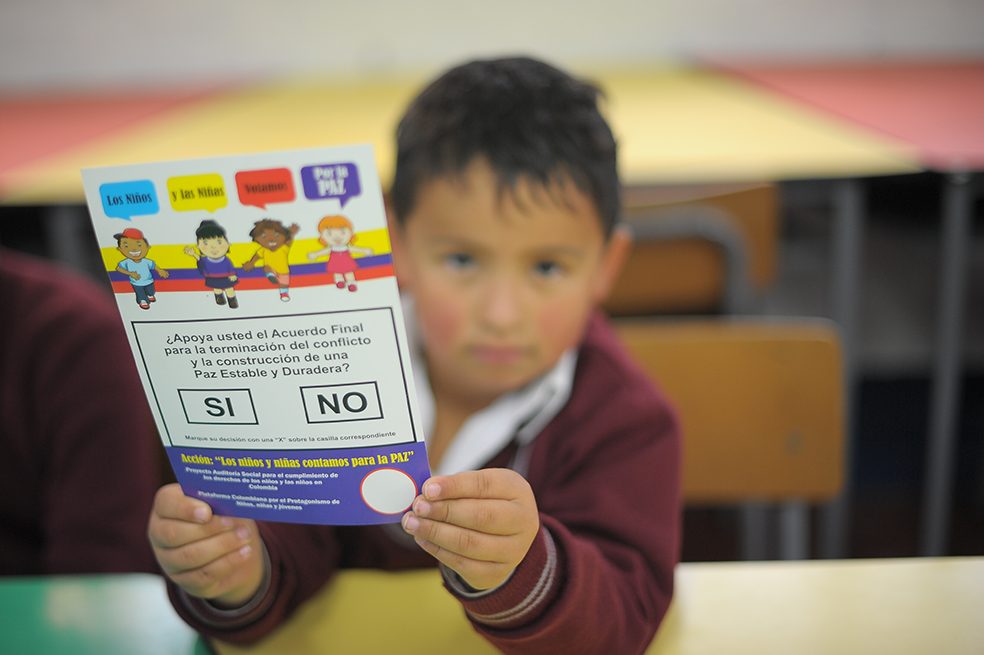 El jurado de cinco años sostiene el tarjetón del plebiscito de los niños. / Cristian Garavito