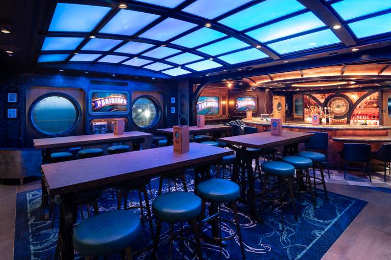 Los viajeros se podrán sumergir en las profundidades míticas de océanos inexplorados en el Periscope Pub. Sirviendo como el primer lugar de Disney Cruise Line inspirado en la fascinante aventura de la película de Walt Disney de 1954, “20,000 leguas de viaje submarino” y la atracción heredada de los Parques de Disney, los interiores de estilo submarino brindan a los visitantes una mirada al mundo acuático que se encuentra debajo a través de un techo de cristal intrigante.