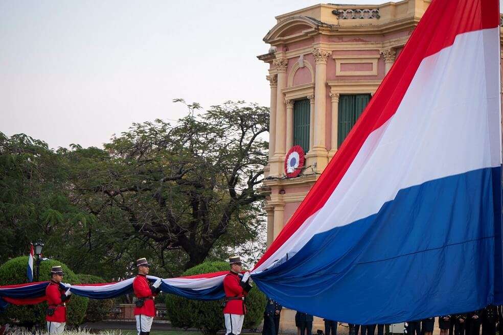 Personal de la Guardia Presidencial iza la bandera paraguaya este jueves en el Palacio de Gobierno en Asunción (Paraguay). / EFE