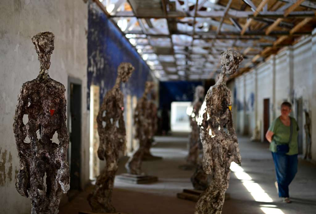 (FILES) A visitor walks past British artist Stuart N. R. Wolfe's "Statues Against Forgetting" installation in a former workshop at the Ravensbrueck concentration camp, close to Fuerstenberg, north of Berlin, on April 29, 2025.