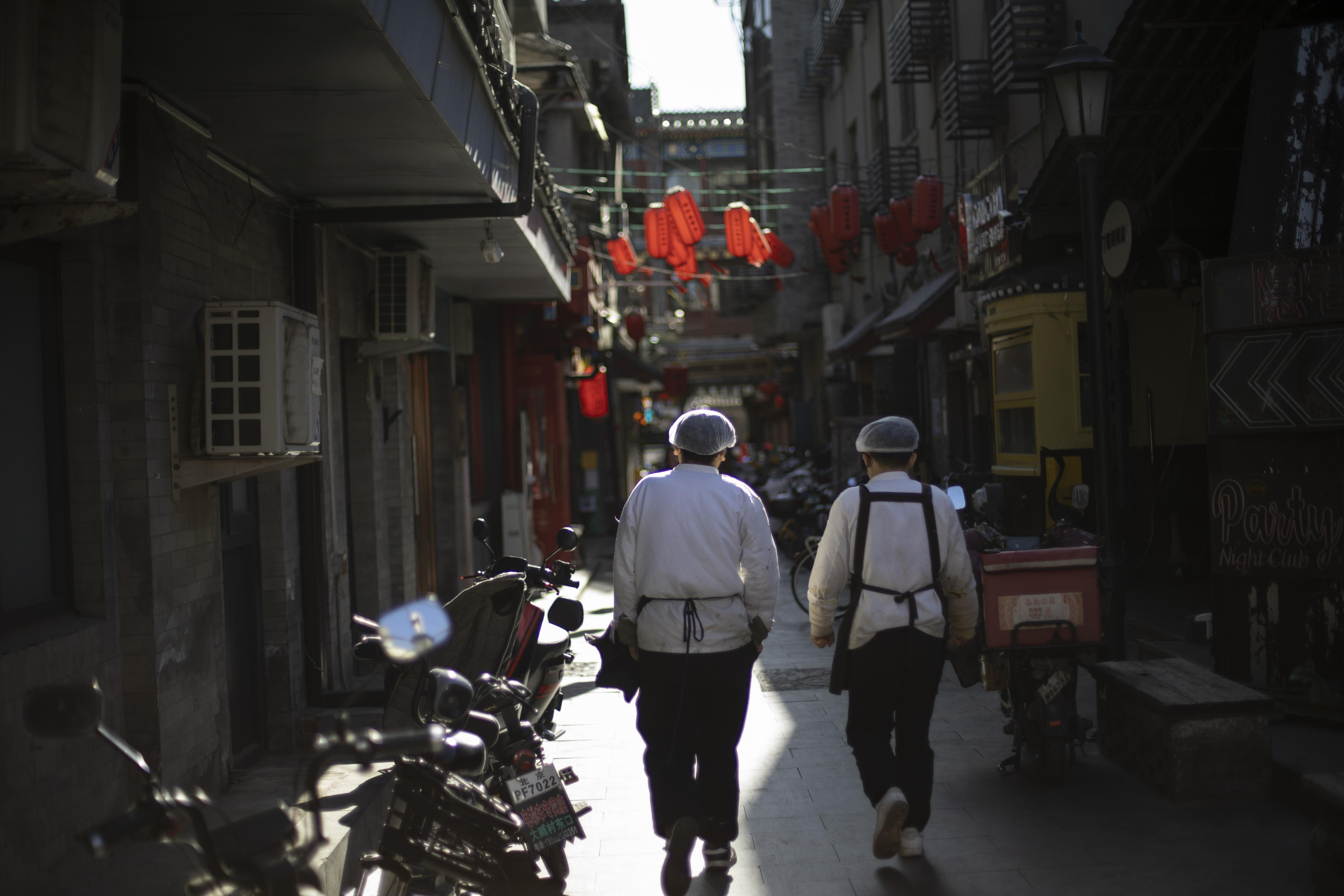Beijing (China), 27/01/2025.- Two restaurant workers walk along a street in Beijing, China, 27 January 2025, ahead of the Lunar New Year. The Chinese Lunar New Year, also called the Spring Festival, falls on 29 January 2025, marking the beginning of the Year of the Snake. EFE/EPA/ANDRES MARTINEZ CASARES