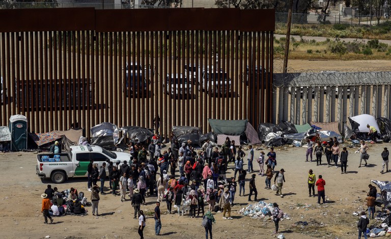 MEX4646. TIJUANA (MÉXICO), 10/05/2023.- Fotografía general donde se observa a migrantes en un campamento junto al muro fronterizo, el 9 de mayo de 2023, en Tijuana, Baja California (México). Tan solo en Tijuana, en la frontera con California, miles de migrantes de diversas nacionalidades, incluyendo familias completas y niños se congregan entre los muros fronterizos días antes de que culmine el Título 42, la noche del jueves, para pedir asilo humanitario en Estados Unidos. El campamento ha ido creciendo desde el fin de semana pasado con personas de Colombia, Venezuela, Perú, Haití, y Honduras, pero también de países lejanos como Turquía y Bosnia, así como mexicanos de los estados sureños de Michoacán y Guerrero, donde la violencia del crimen organizado los desplaza.EFE/Joebeth Terriquez