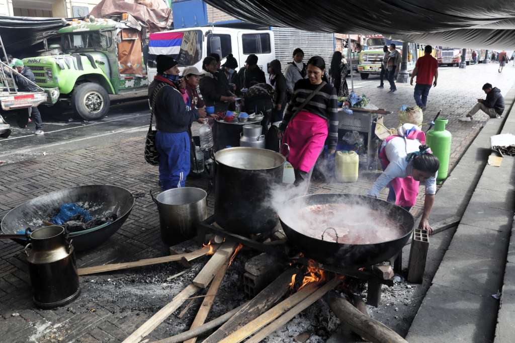 AME5051. BOGOTÁ (COLOMBIA), 03/04/2025.- Indígenas preparan alimentos este jueves, en la Plaza de Bolívar en Bogotá (Colombia). Indígenas del suroeste de Colombia acampan en el centro de Bogotá buscando una reunión con el presidente, Gustavo Petro, para pedir soluciones a sus problemas de educación, tierras y seguridad. EFE/ Carlos Ortega