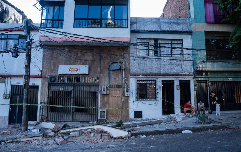 AME7880. PEREIRA (COLOMBIA), 10/08/2026.- Personas observan viviendas afectadas luego de un terremoto de magnitud 7,4 este lunes, en Pereira (Colombia). "Desde hoy a la seis de la tarde hemos decretado toque de queda hasta las cinco de la mañana para proteger el comercio de la ciudad. Este toque de queda será en el centro de Pereira, en la Comuna Universidad y en el subcentro Cuba", manifestó el alcalde de Pereira, Mauricio Salazar. EFE/ Leonardo Castañeda