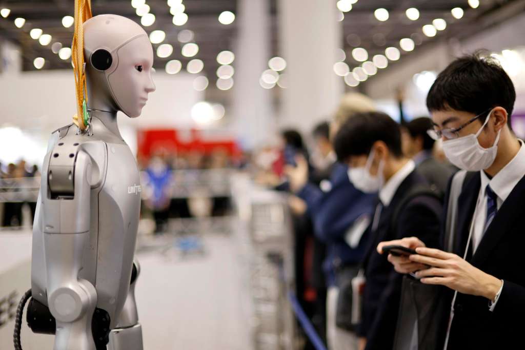 TOKYO (Japan), 03/12/2025.- A visitor stands next to a humanoid robot at the TechShare booth during the International Robot Exhibition 2025 (iREX2025) in Tokyo, Japan, 03 December 2025. Held once every two years, the iREX is one of the world’s largest robot trade shows. For the 2025 edition, 673 companies and organizations will be presenting their latest robot technologies until 06 December. (Japón, Tokio) EFE/EPA/FRANCK ROBICHON