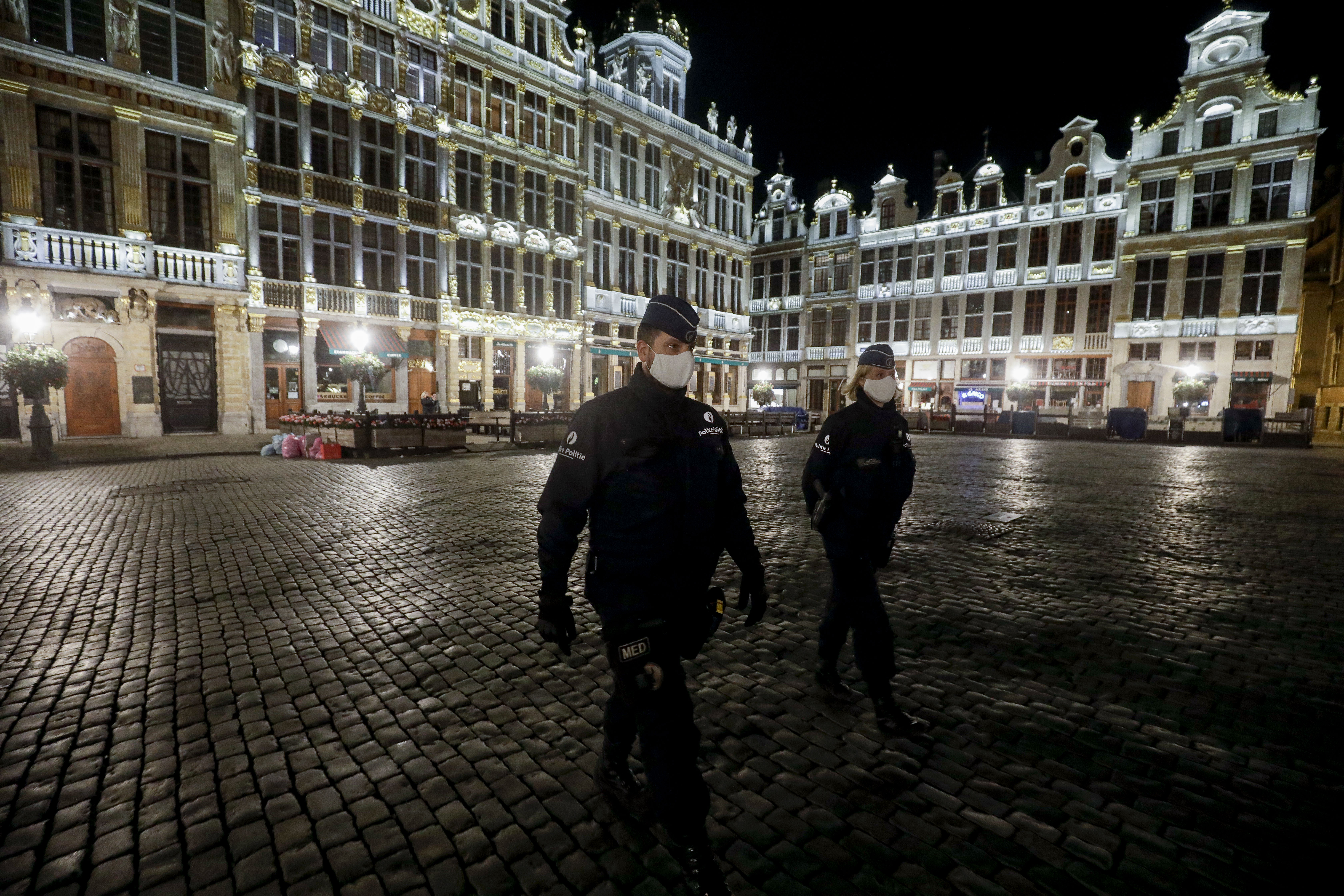 Agentes de policía con máscaras protectoras patrullan al inicio del toque de queda en Bruselas el 19 de octubre de 2020 como medida contra la propagación de la pandemia COVID-19 causada por el nuevo coronavirus.