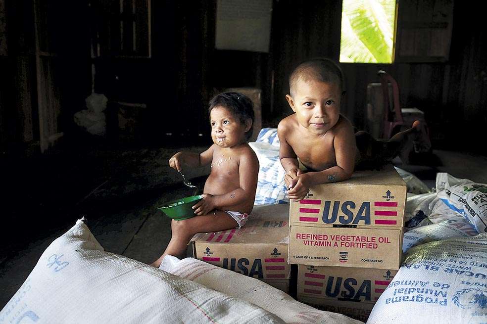 Los menores indígenas son particularmente vulnerables al drama de la desnutrición. En la foto, dos niños emberas de Nariño sentados sobre ayuda humanitaria. / Nelson Sierra G.