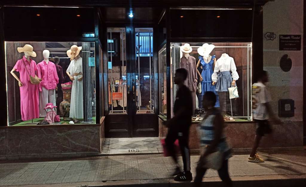 AME9793. LA HABANA (CUBA), 29/05/2024.- Personas caminan frente a una tienda de ropa el 28 de mayo de 2024 en La Habana (Cuba). Las mipymes, que han contribuido a aliviar la escasez de alimentos en la isla, han sido con frecuencia víctimas de la polarización política cubana, pues unos sectores las acusan de atizar la inflación y ser punta de lanza de Washington, mientras otros denuncian que están controladas por la élite del sistema cubano. EFE/Ernesto Mastrascusa