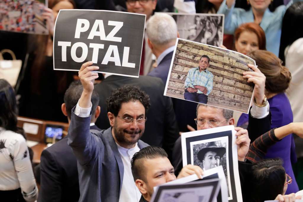 BOG400. BOGOTÁ (COLOMBIA), 20/07/2022.- El senador Iván Cepeda (i) muestra un cartel que dice "Paz total" hoy, durante la instalación del nuevo Congreso Nacional, en Bogotá (Colombia). El presidente colombiano, Iván Duque, instala este miércoles el nuevo Congreso Nacional, elegido el 13 de marzo, que tendrá entre sus tareas discutir las reformas prometidas por su sucesor, Gustavo Petro, quien asumirá el 7 de agosto. EFE/Carlos Ortega