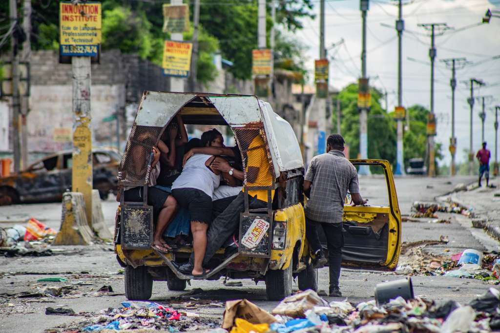 -FOTODELDÍA- AME2533. PUERTO PRÍNCIPE (HAITÍ), 02/05/2024.- Personas se transportan en un automóvil con sus pertenencias después de un ataque de bandas armadas en el sector de Delmas 22 este jueves, en Puerto Príncipe (Haití). El Gobierno de Haití extendió este miércoles por tres días el toque de queda en el departamento Oeste, donde se localiza Puerto Príncipe, capital cuya mayor parte de su territorio está dominado por bandas armadas que imponen el terror entre la ciudadanía. EFE/ Mentor David Lorens