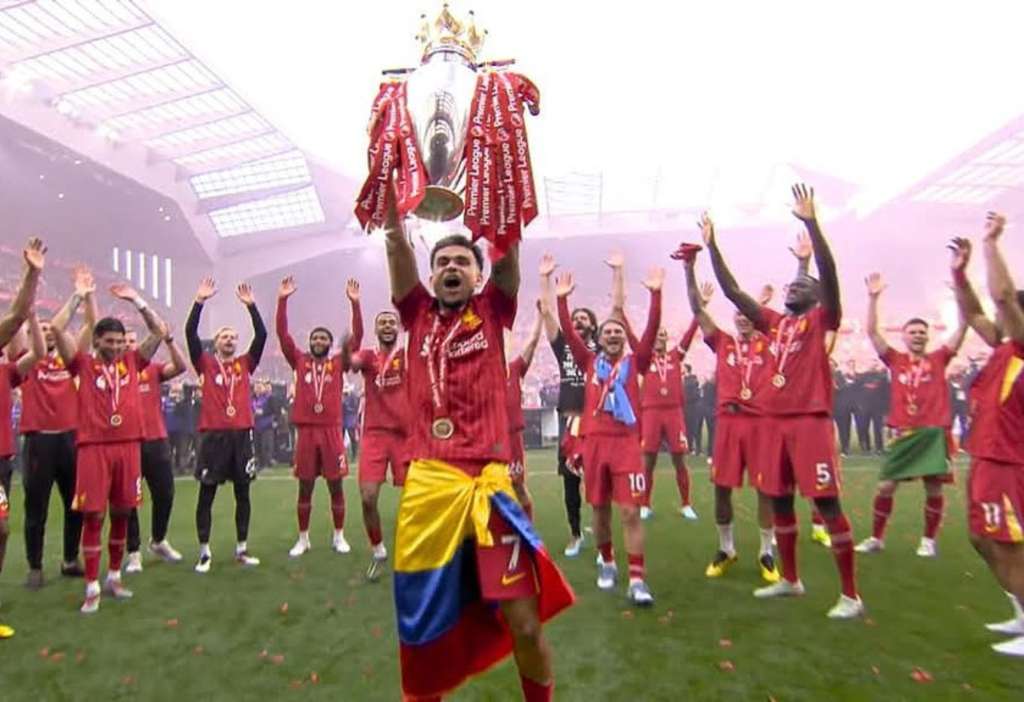 El delantero colombiano Luis Díaz levanta el trofeo de la Premier League en medio de sus compañeros del Liverpool.