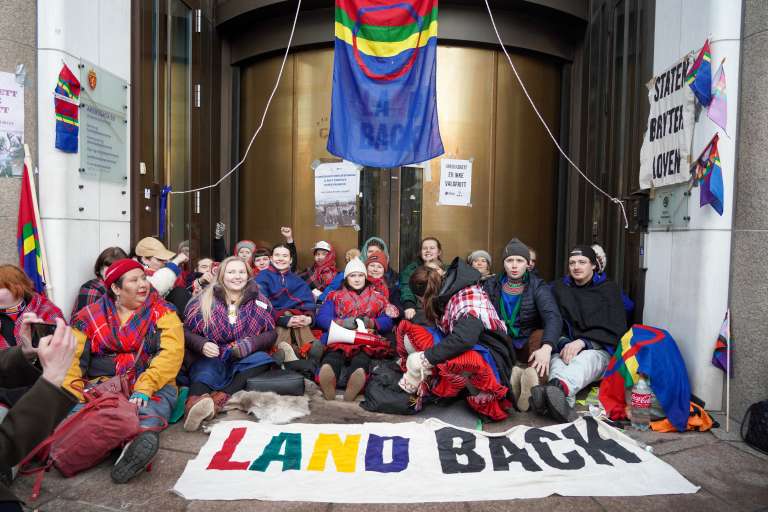 Los manifestantes perseguían "cerrar el Estado" como protesta por la continua actividad de turbinas eólicas en la región de Fosen, más de un año después de que la Corte Suprema noruega se pronunciara contra estos parques.
Según el tribunal, este proyecto viola el derecho de las familias sami a practicar la cría de renos. Los samis son una minoría indígena de unas 100.000 personas que viven entre Noruega, Suecia, Finlandia y Rusia.
La protesta comenzó el jueves pasado cuando un grupo de samis vestidos con el traje tradicional azul y rojo ocuparon la entrada del Ministerio de Petróleo y Energía.
Los activistas fueron desalojados en la noche del domingo, pero volvieron durante la semana, extendiendo la toma a más edificios del gobierno.