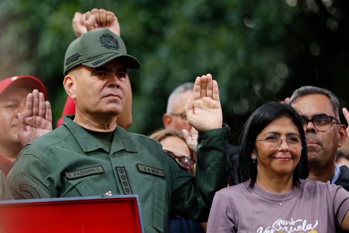 (FILES) Venezuelan Defence Minister General Vladimir Padrino (L) and the Vice President of Venezuela, Delcy Rodríguez, gesture during a rally in Caracas on August 28, 2024.