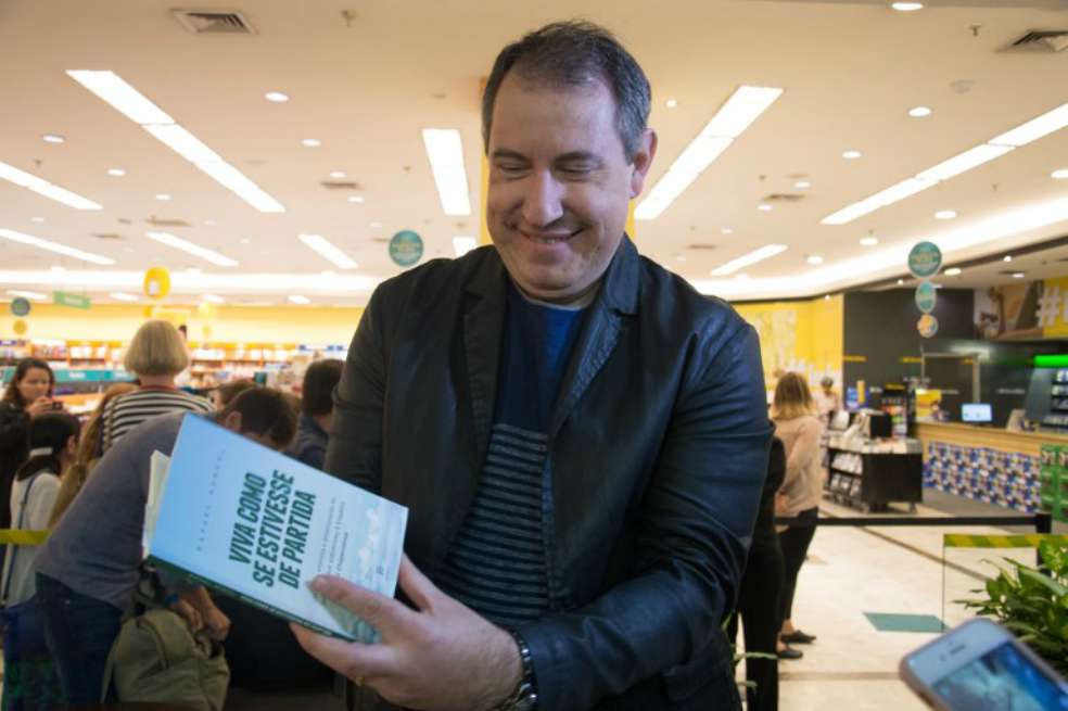 El periodista brasileño Rafael Henzel, uno de los sobrevivientes del accidente aéreo en que murió la mayor parte del equipo de fútbol Chapecoense, en Colombia en noviembre pasado, muestra su libro. / AFP