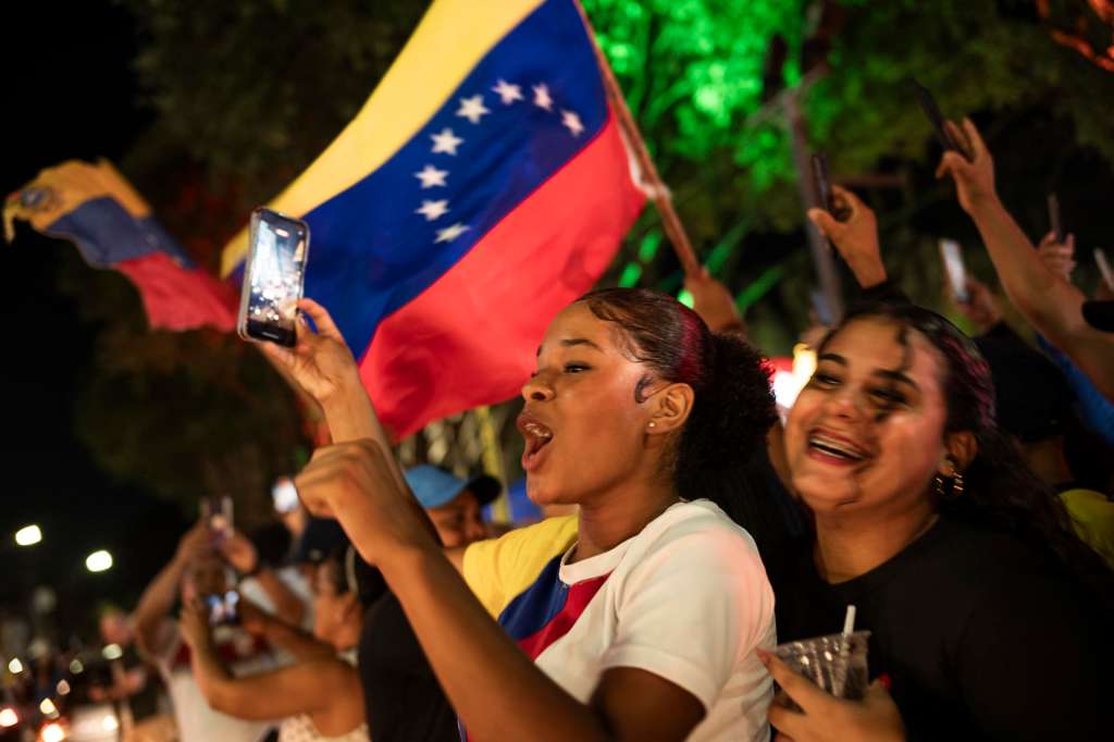AME2056. MANAOS (BRASIL), 03/01/2026.- Personas sostienen banderas de Venezuela durante una manifestación este sábado, en Manaos (Brasil). La captura de Nicolás Maduro, y de su esposa, Cilia Flores, en la madrugada de este sábado por parte de EE.UU., en una operación denominada Resolución Absoluta, que incluyó varios bombardeos sobre el país, ha dividido al continente americano entre quienes celebran el fin del mandato del chavista y quienes denuncian las acciones estadounidenses como ilegales. EFE/ Raphael Alves