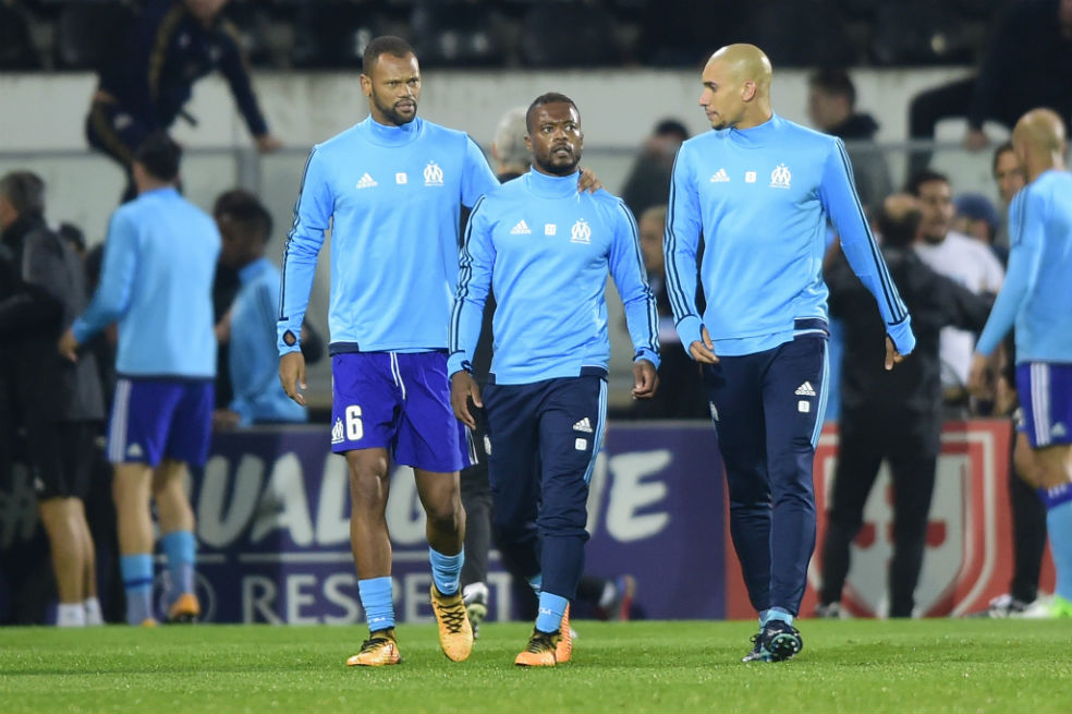 Evra sale escoltado por sus compañeros de equipo. / AFP