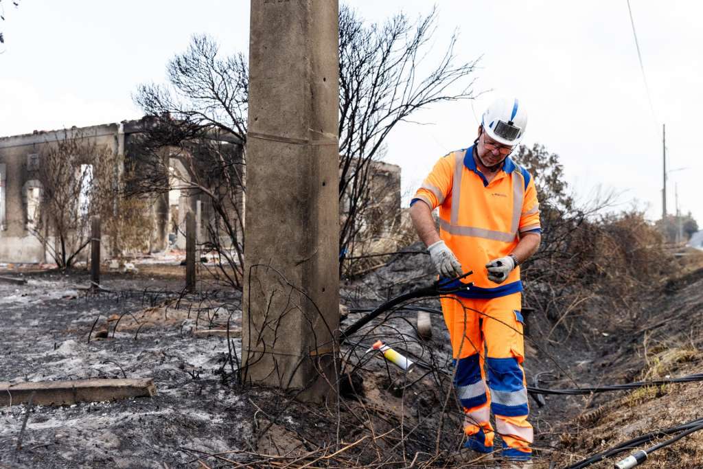 Le Porge (France), 30/07/2026.- NGE Energie Solutions personnel work to secure power lines in front of fire damaged houses following wildfires in Le Porge, France, 30 July 2026. Most of the residents of the town evacuated as the fires approached Le Porge. (Francia) EFE/EPA/Sophie Garcia