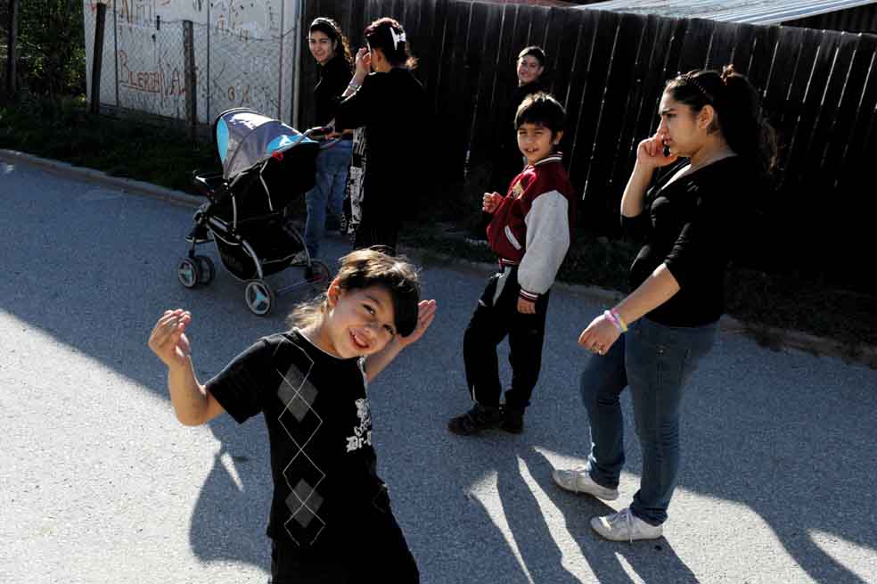Leonarda Dibrani (der.), camina con su familia por la ciudad de Mitrovica, en Kosovo. / AFP