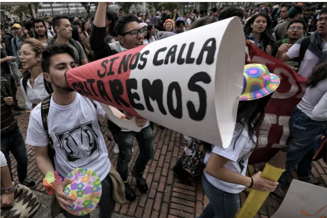 Jóvenes manifestándose en las calles. Uno de ellos tiene un cono con el que amplifica el mensaje: "si nos calla gritaremos".