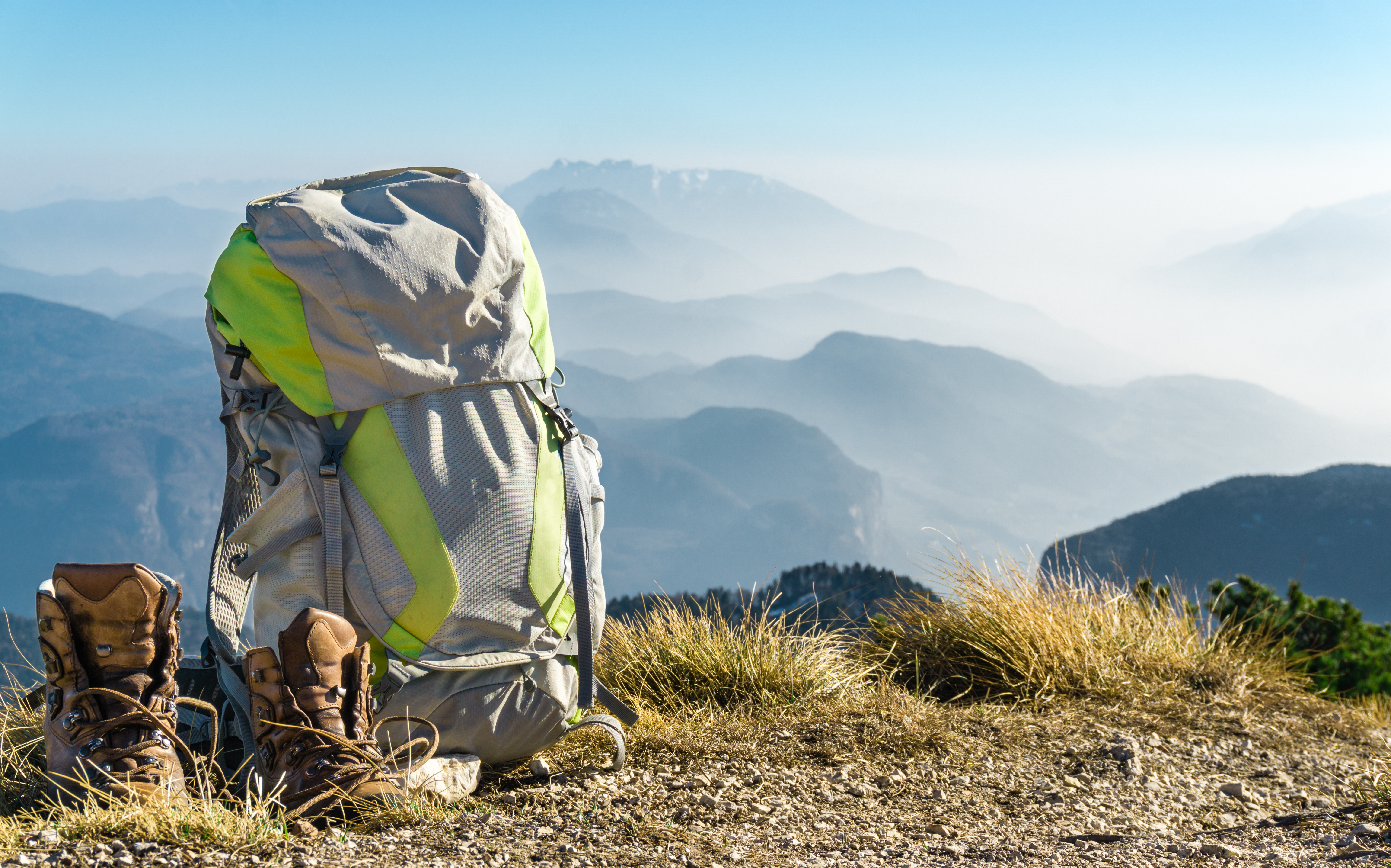 Hiking equipment. Backpack and boots on top of the mountain.