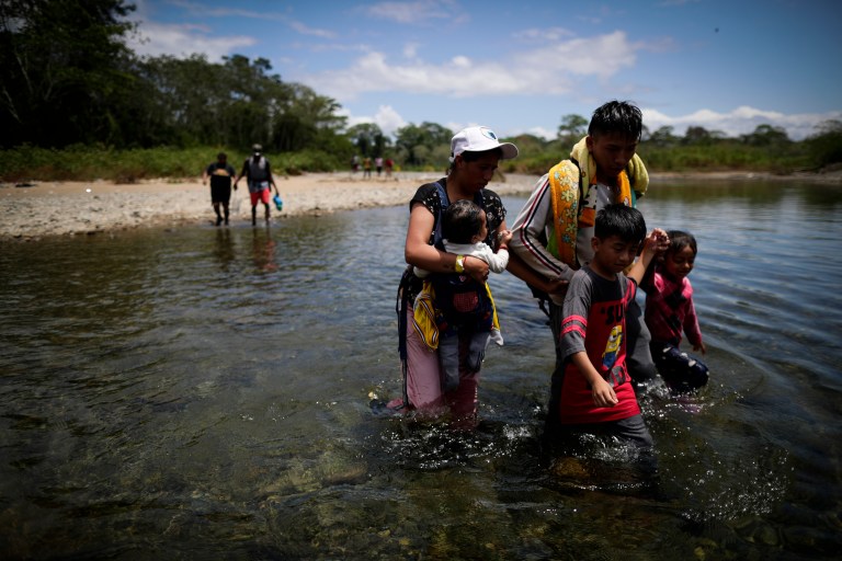 -FOTOGALERÍA- AME4250. BAJO CHIQUITO (PANAMÁ), 21/03/2023.- Jesenia Pérez y su hijo cruzan el río Tuquesa para ser trasladados en canoa desde la Quebrada León hasta a la comunidad de Bajo Chiquito, el 10 de marzo de 2023, en Darién (Panamá). "Guerreros", repiten las madres, hijos guerreros que han aguantado largas caminatas, hambre, sed, el calor, picaduras de insectos, superar ríos y cerros, para sobrevivir a la selva del Darién en su ruta hacia Estados Unidos. Recién salidos de esta selva que hace de frontera natural entre Colombia y Panamá, los migrantes llegan hasta la conocida como Quebrada del León, donde les esperan unas piraguas de indígenas que los descenderán por el casi seco río Tuquesa hasta Bajo Chiquito, una pequeña población emberá donde podrán al fin reposar tranquilos. Robaron al grupo de la venezolana Jessenia Pérez, de 30 años, que viaja con diez niños, entre hijos y sobrinos. La joven piensa en otros migrantes que intentarán como ellos atravesar la selva, y les lanza una recomendación que repiten otros recién llegados: "Si ustedes vienen, en grupos grandes, no se queden atrás, porque los que van atrás sufren lo peor, robo y de todo". EFE/ Bienvenido Velasco