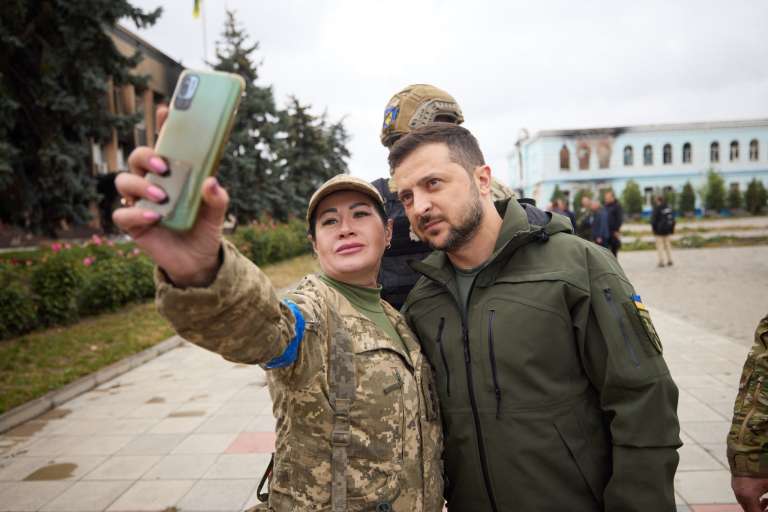 El presidente ucraniano Volodymyr Zelensky posando para una selfie con una militar en la ciudad desocupada de Izyum, región de Kharkiv.