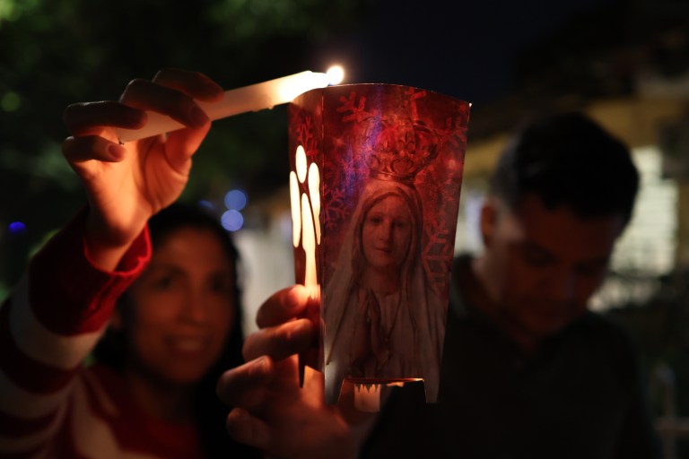 AME2779. CALI (COLOMBIA), 07/12/2023.- Una familia enciende velas en el tradicional día de velitas, costumbre colombiana que celebra el día de la Inmaculada Concepción y marca el inicio de la Navidad, hoy en Cali (Colombia). EFE/Ernesto Guzmán