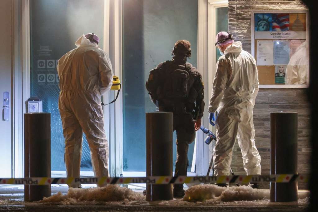 TOPSHOT - Forensic experts and a police officer stand in front the entrance of the US embassy after a loud bang was reported during the night with no injuries reported in Oslo on March 8, 2026. (Photo by Hans O. Torgersen / NTB / AFP) / NORWAY OUT