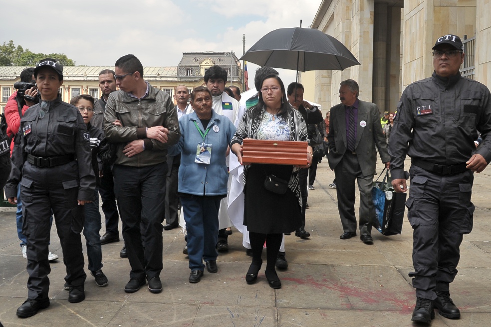 Rosa Milena Cárdenas llevando los restos de su madre, Luz Mary Portela, quien desapareció tras la retoma del Palacio de Justicia en 1985. A su izquerda, su hermano Édison. / Santiago Acosta García